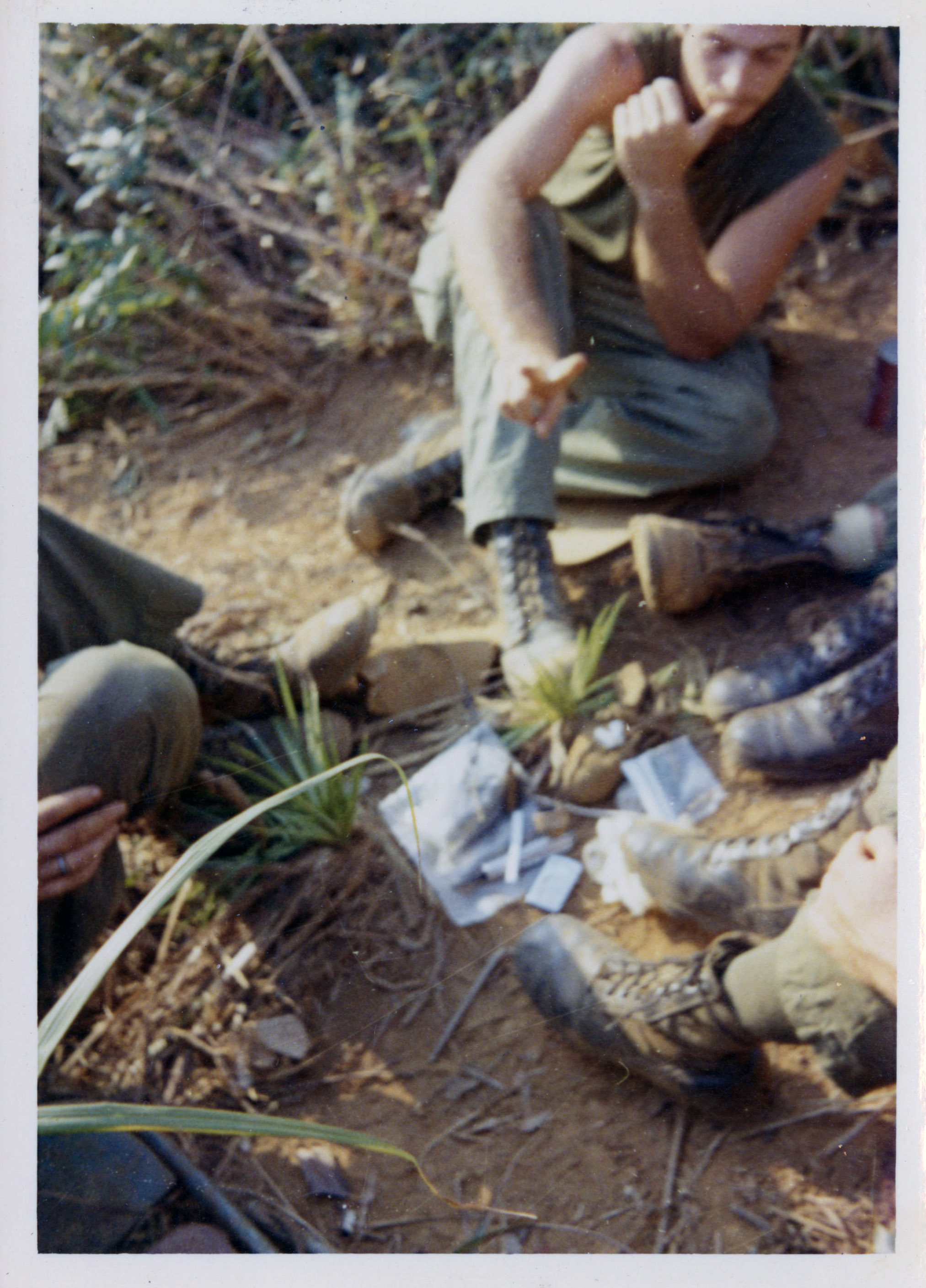 Soldiers sitting in a circle with rolled joints and plastic bags in the middle of them.