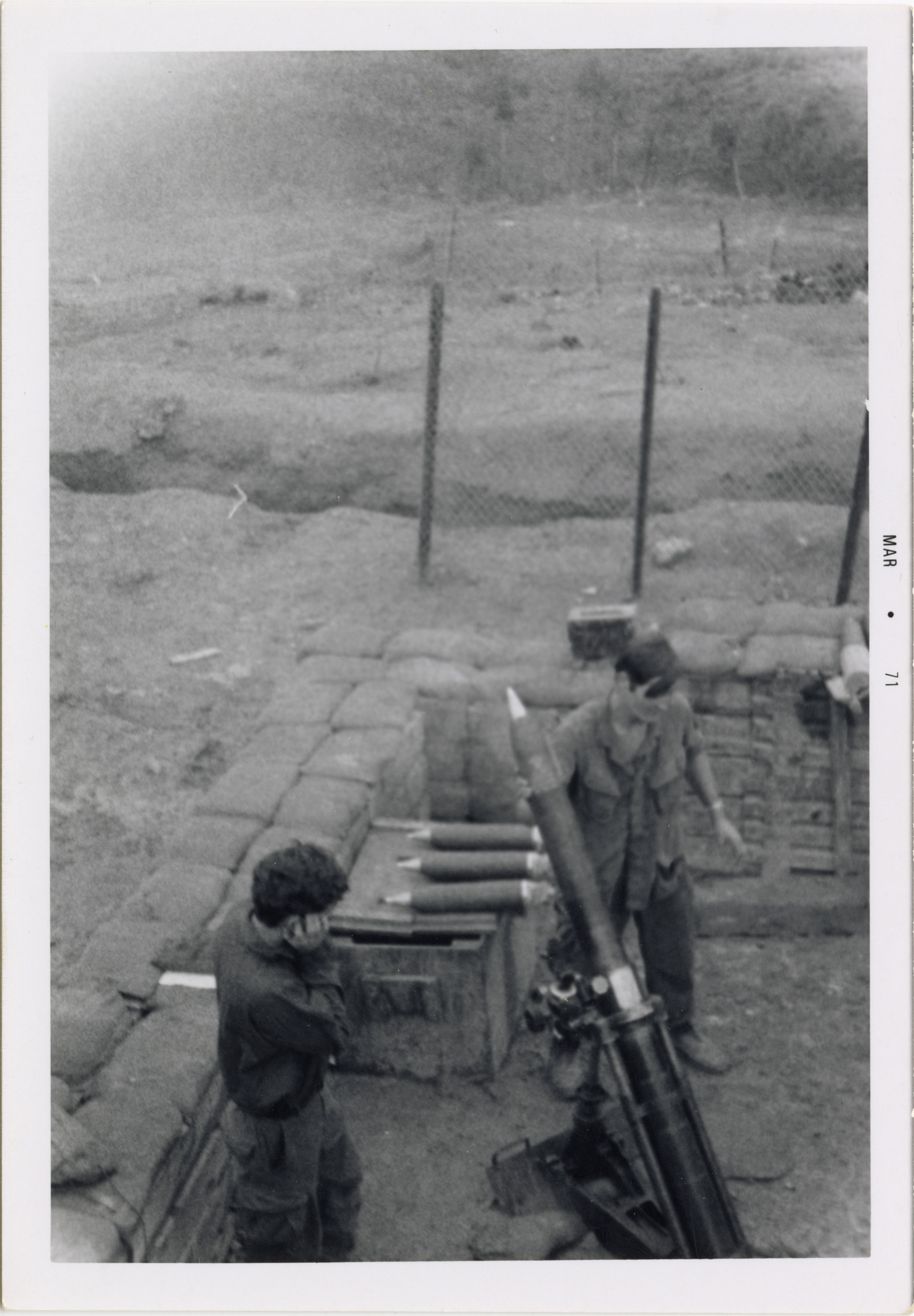 Soldiers are working with the missile launcher while one holds his ear closed.