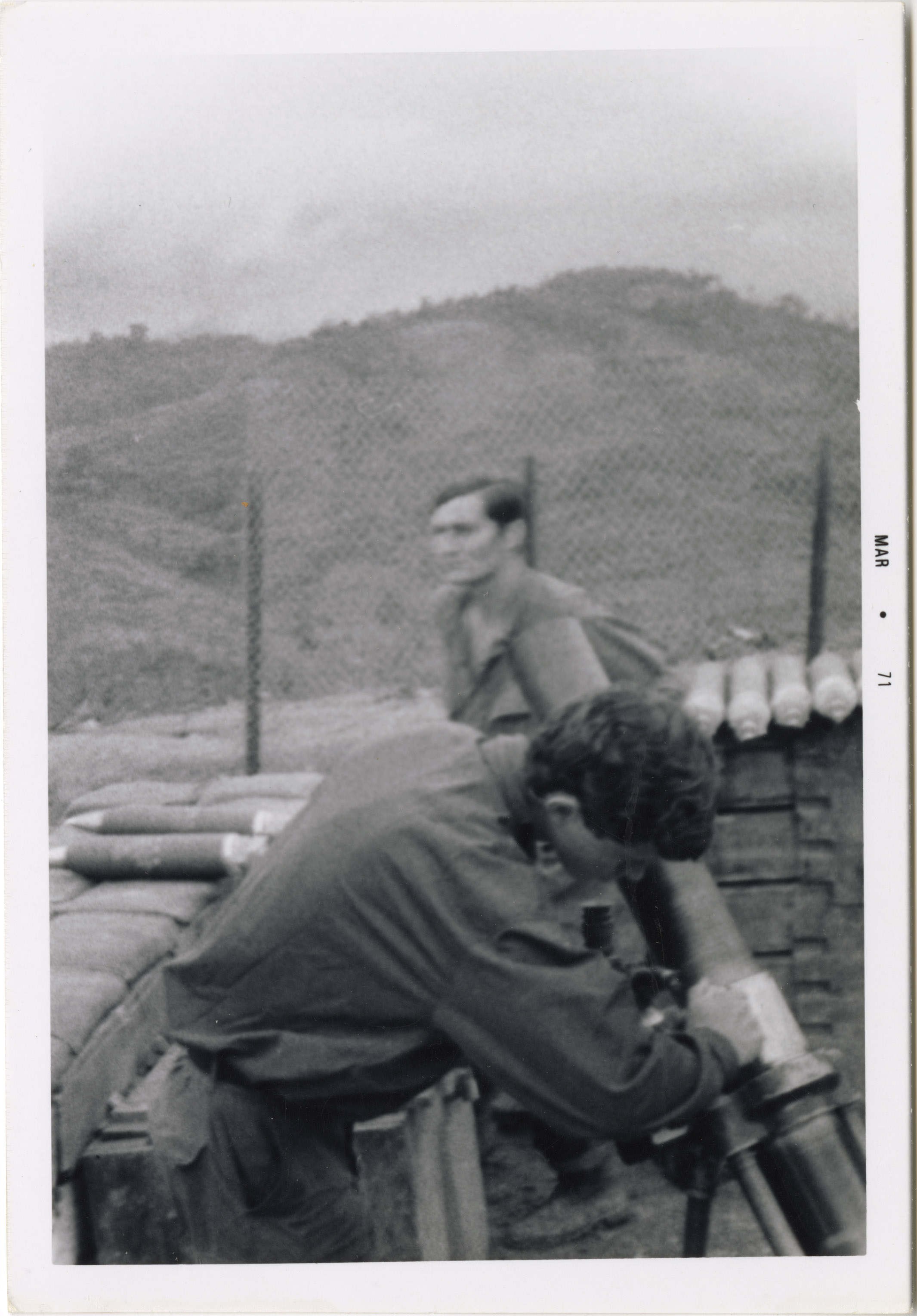 A Vietnam war soldier is reloading a missile into a missile launcher.