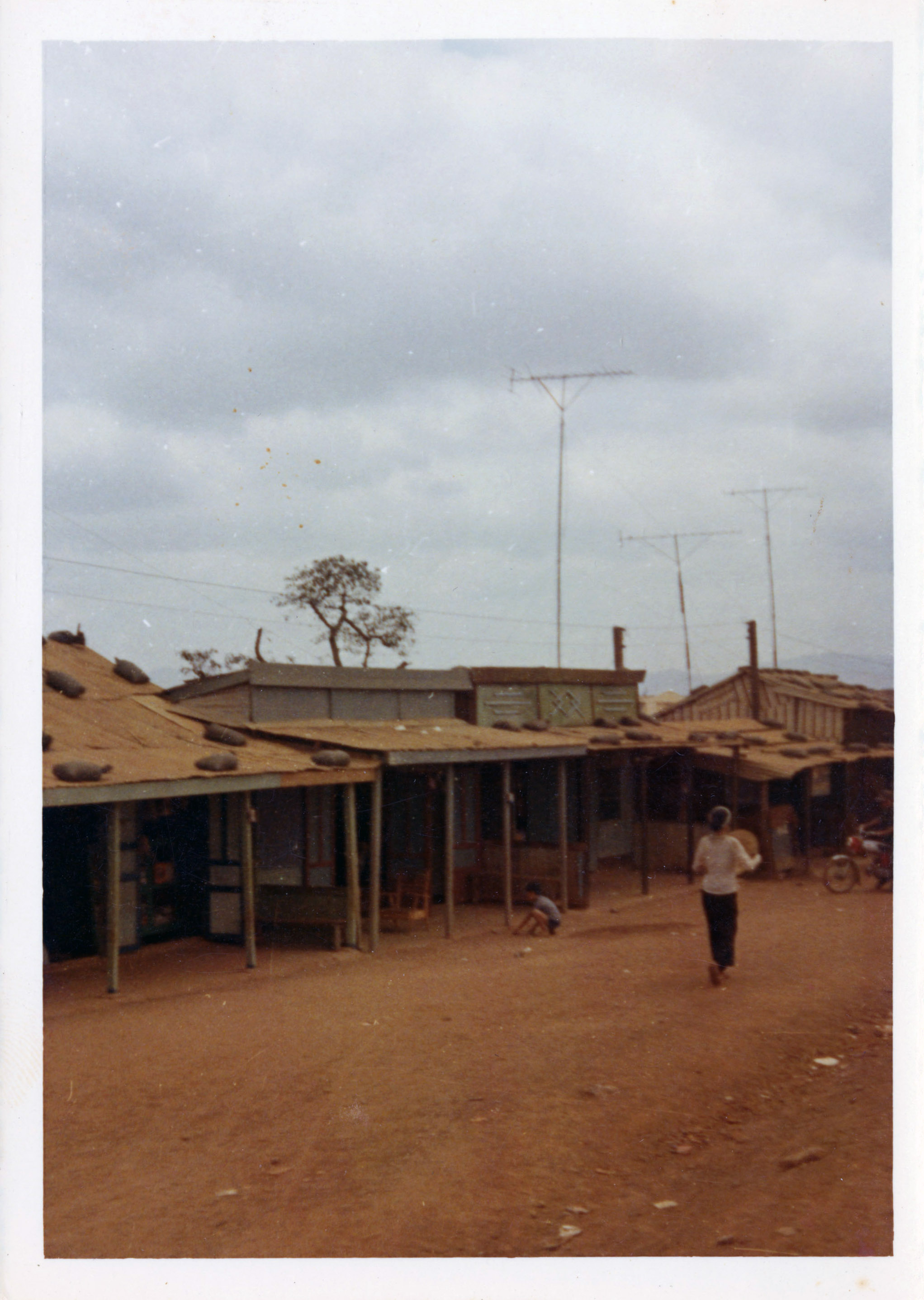 A villager walks down a dirt road in a Vietnamese village.