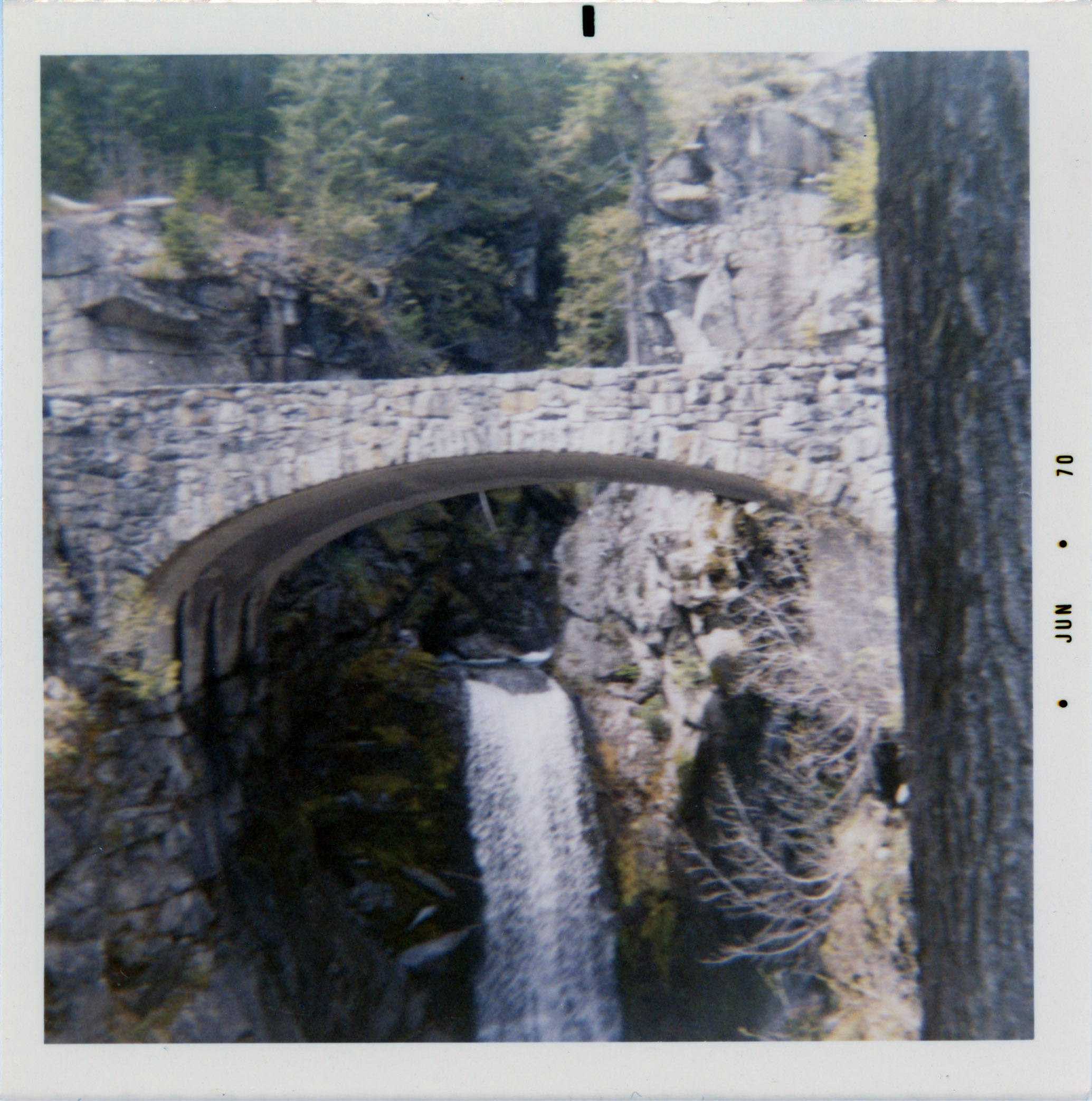 A bridge in Vietnam, specific whereabouts unknown, with a waterfall featured underneath the bridge.