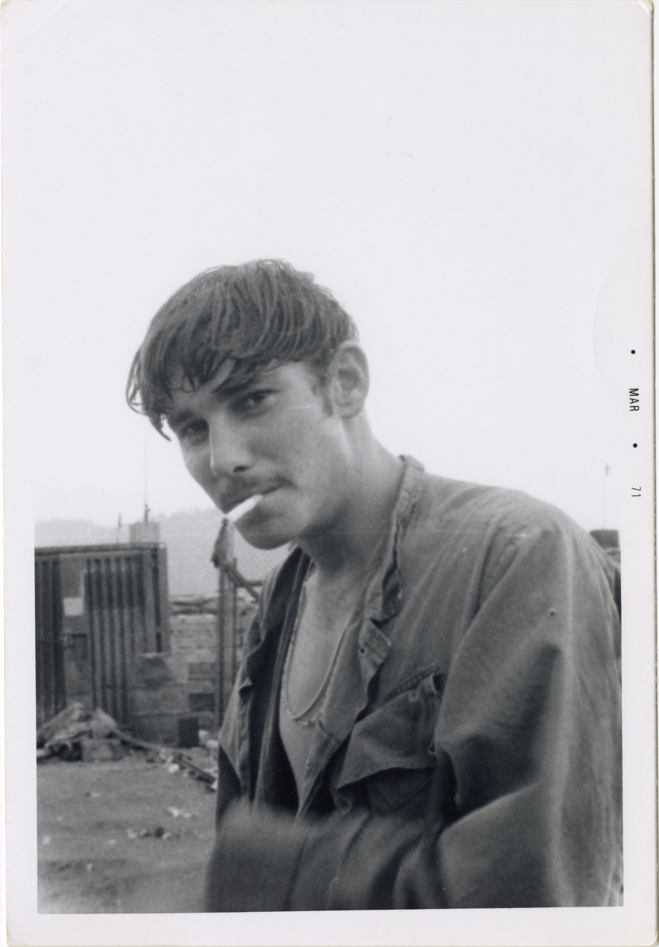 A soldier is smoking a cigarette while posing for the camera.